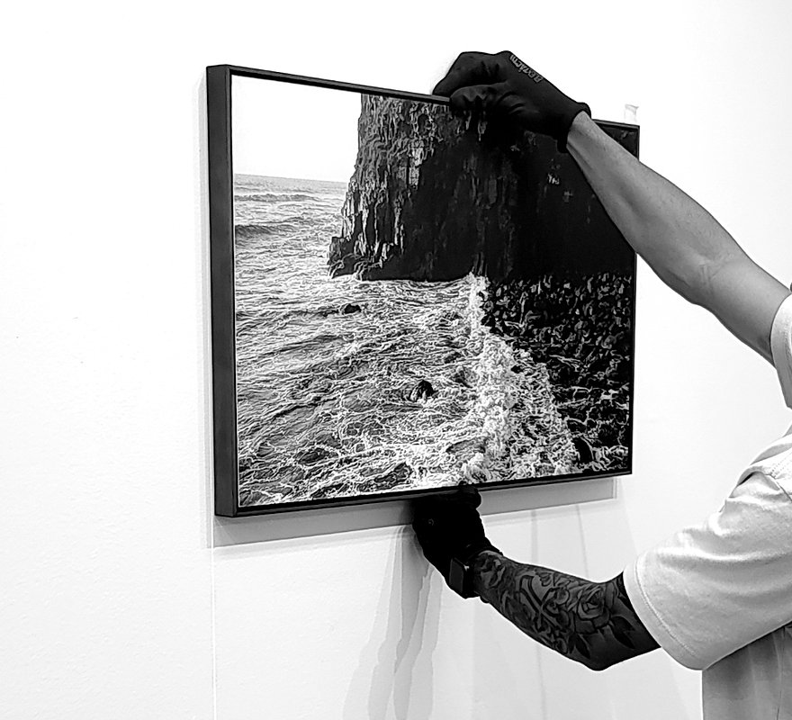 Montagem de uma fotografia emoldurada na parede da galeria